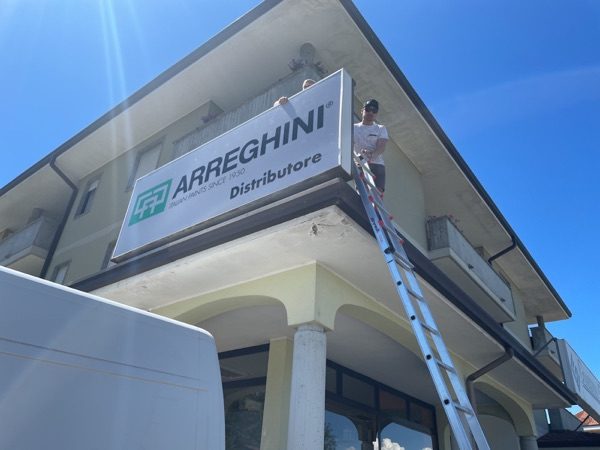 Posa dell’insegna Arreghini Distributore su un edificio
