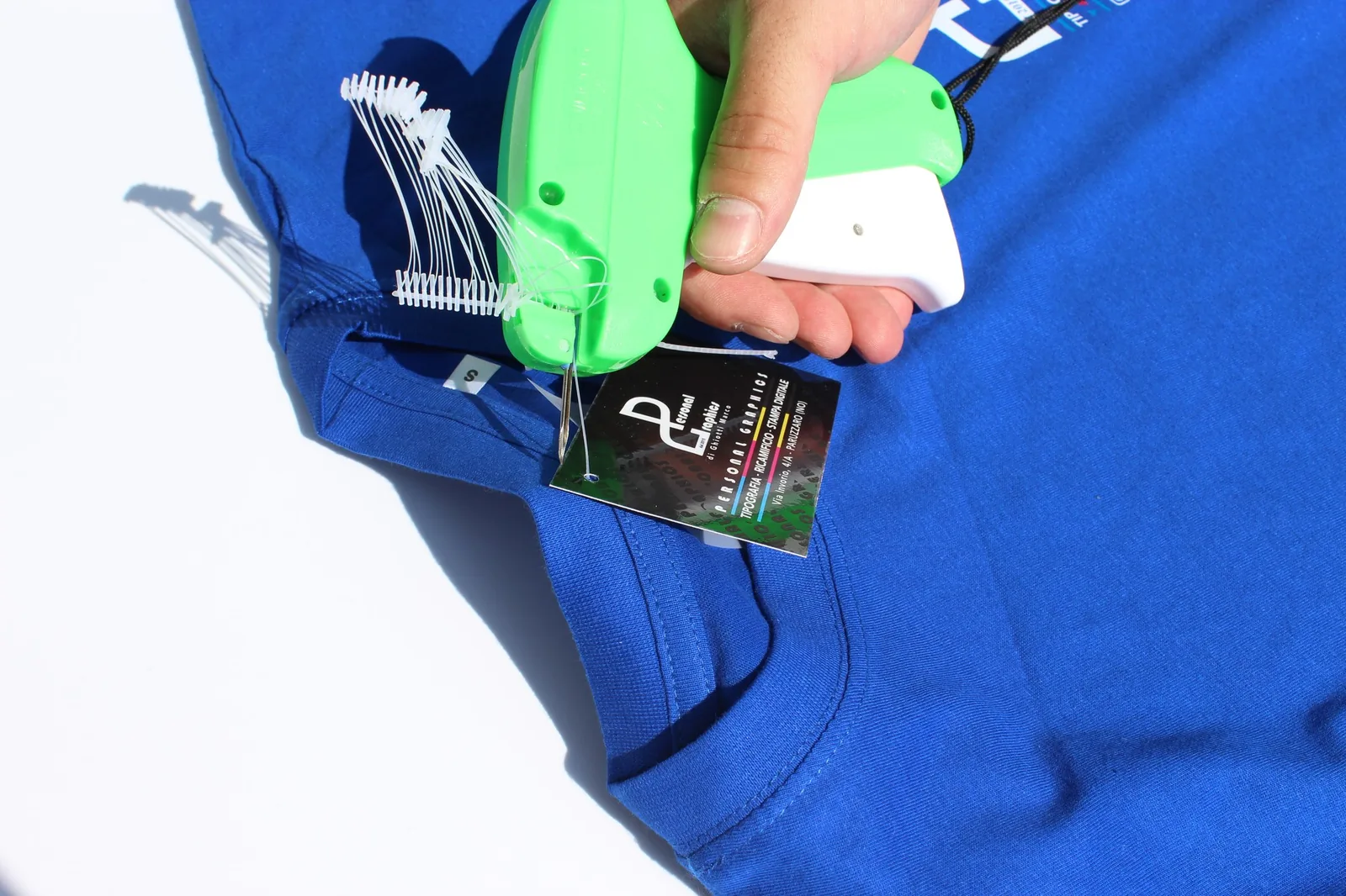 Etichetta al collo e cartellino Personal Graphics su una t-shirt blu