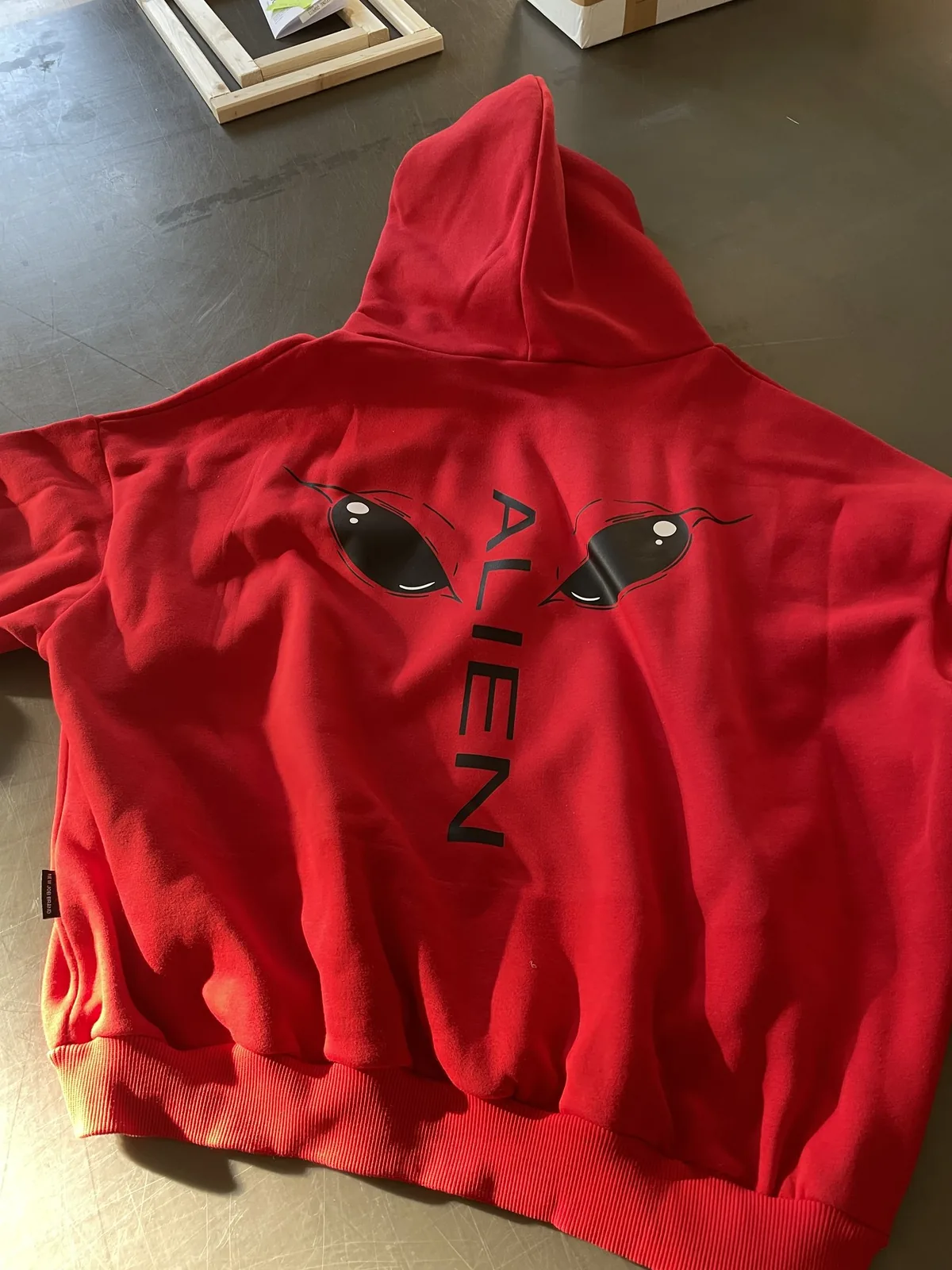 Felpa rossa con il disegno alieno stampato sul cappuccio