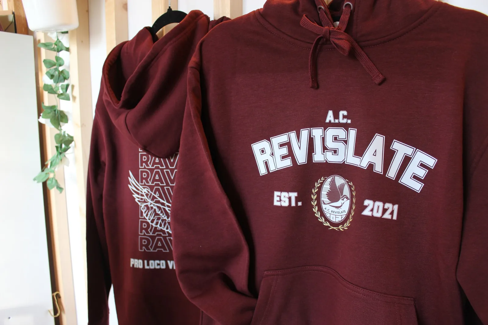 Felpe bordeaux A.C. Revislate appese nello showroom