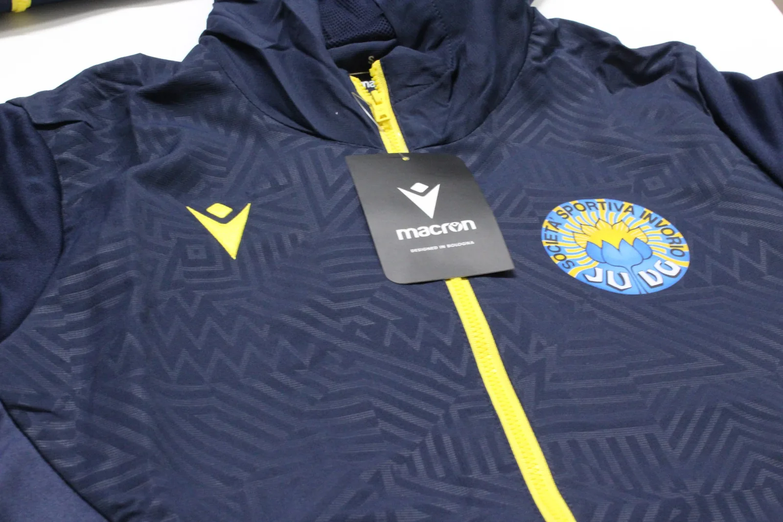 Giacca Macron blu dell’A.S.D. Judo Invorio con zip gialla e logo stampato