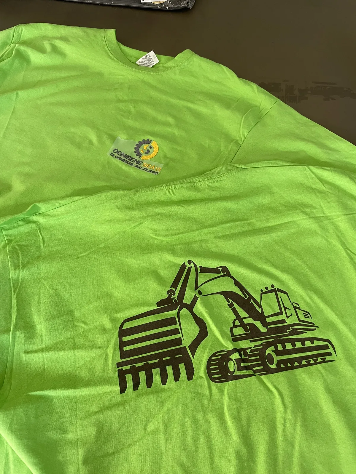 T-shirt verde con l’escavatore stampato e il logo sul petto