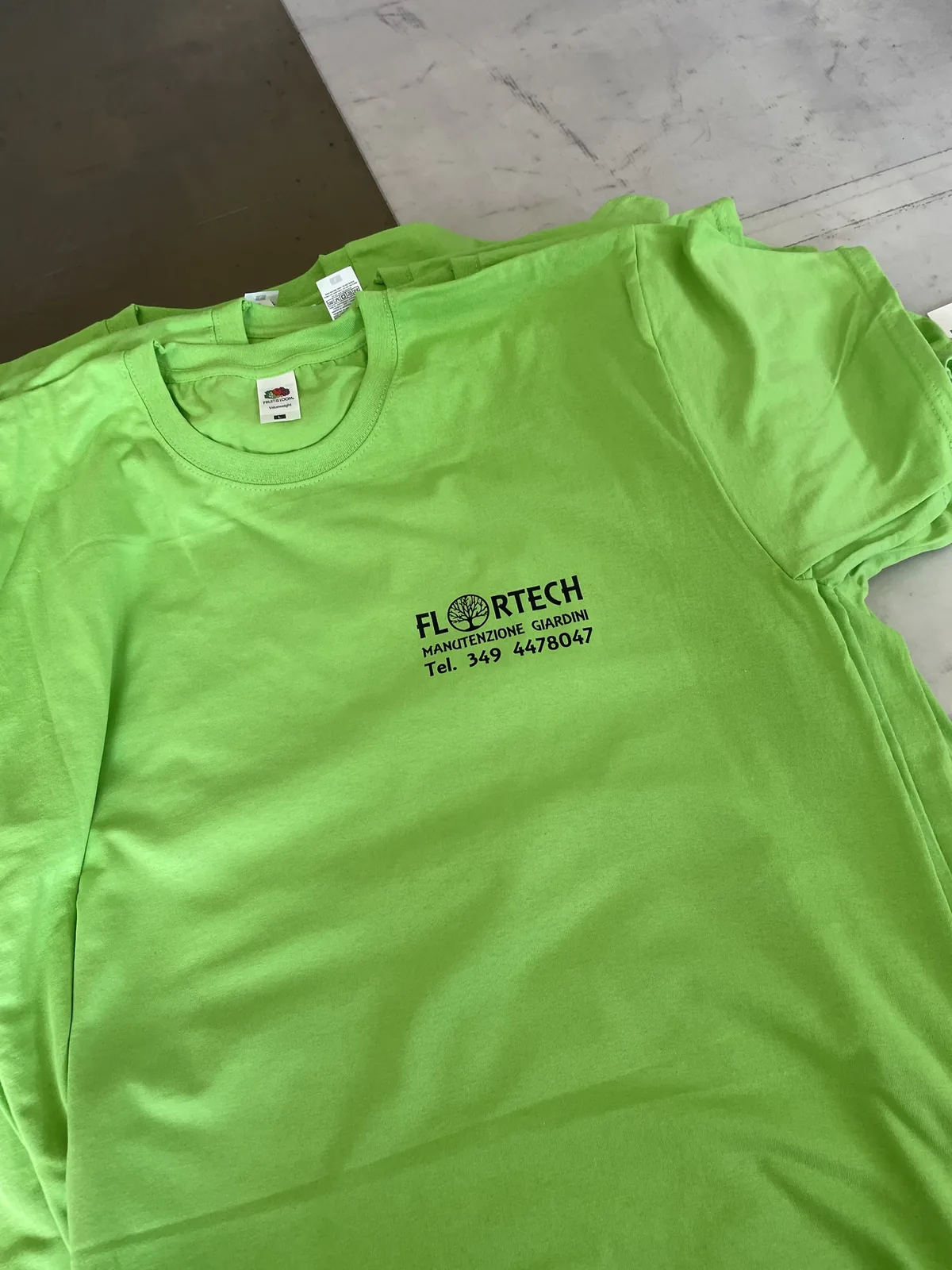 T-shirt verde Flortech con il logo e il telefono stampati sul petto