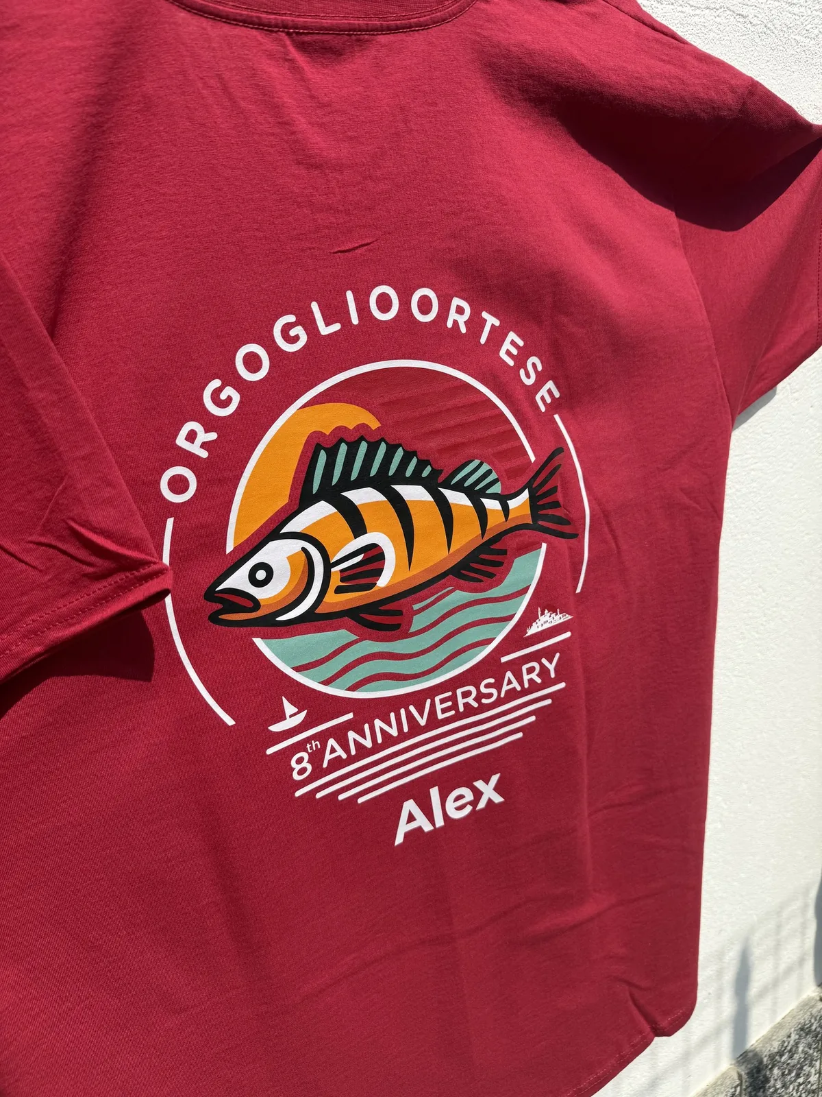 T-shirt rossa Orgoglio Ortese 8° anniversario con il pesce illustrato
