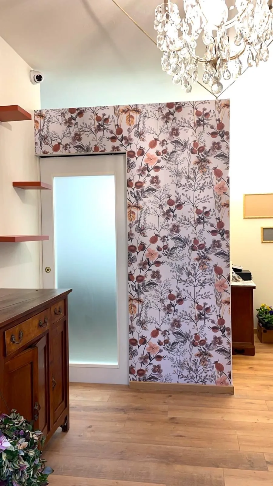 Parete rivestita con carta da parati floreale stampata in un ingresso con mobili antichi