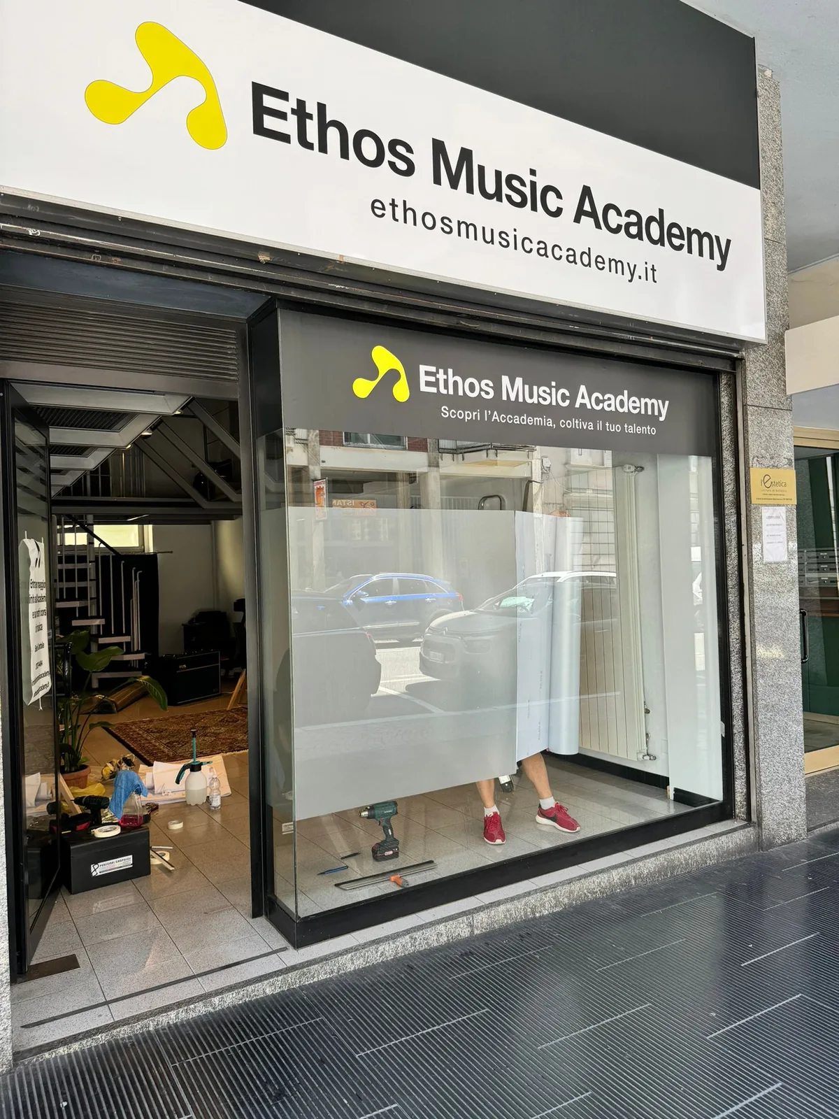 Insegna e vetrofanie Ethos Music Academy sull’ingresso della scuola
