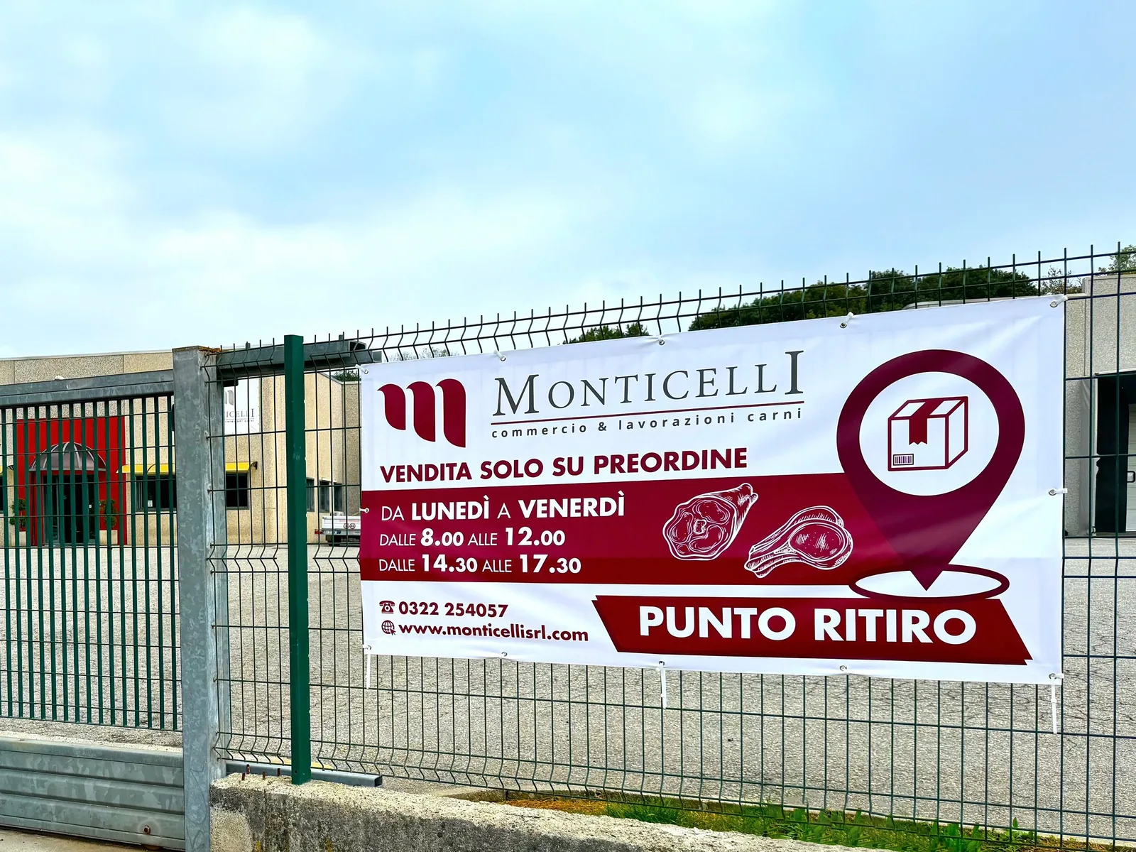 Banner Monticelli «Punto ritiro» con orari, teso sulla recinzione dello stabilimento