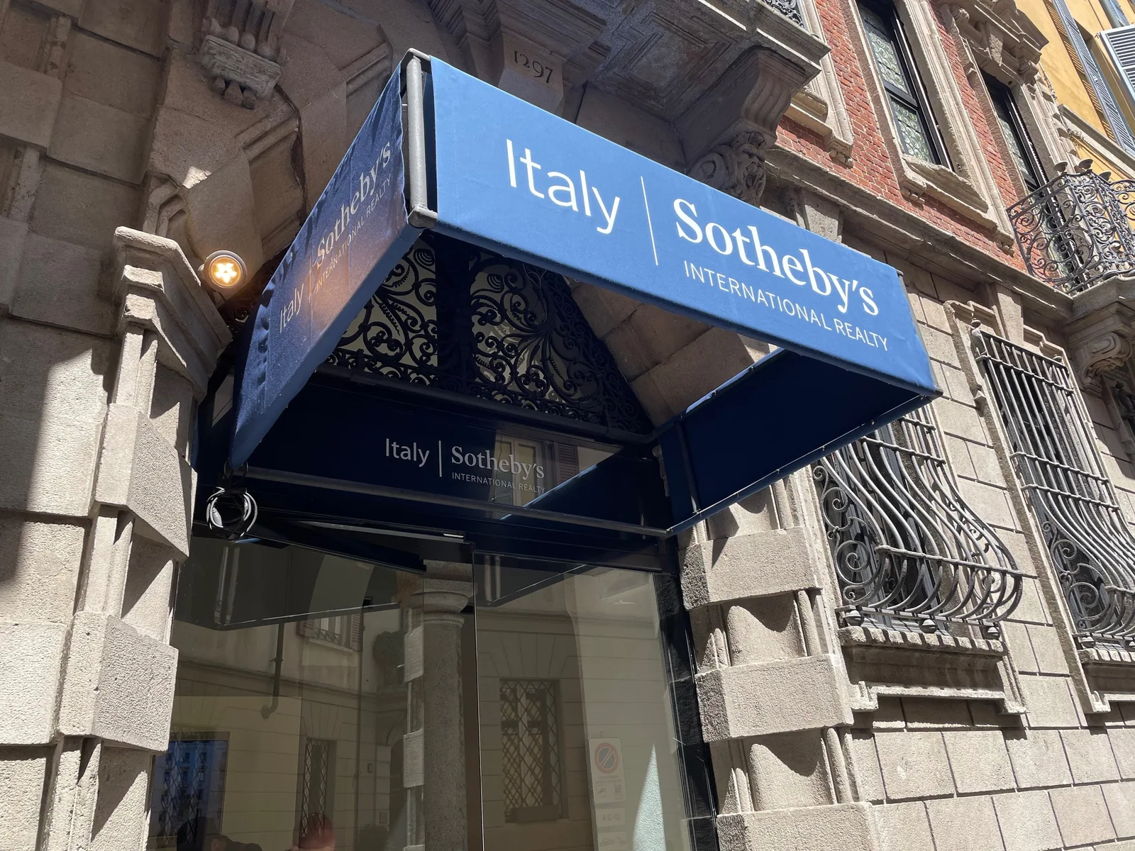 Pensilina Italy Sotheby’s International Realty sopra l’ingresso di un palazzo storico