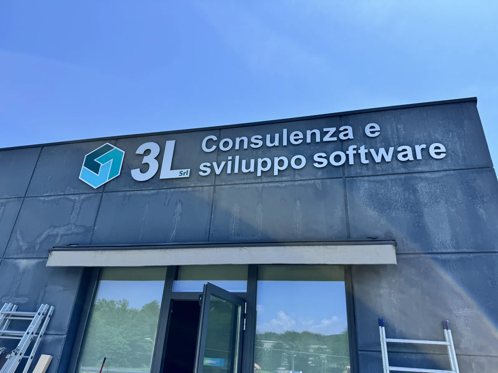 Insegna 3L Consulenza e sviluppo software a lettere in rilievo sulla facciata grigia