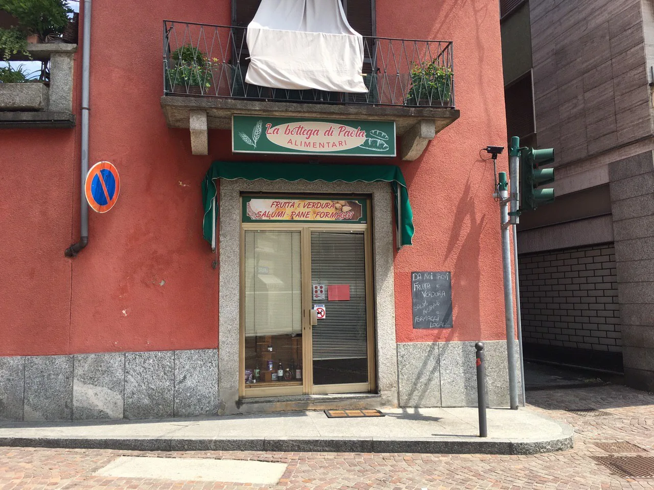 Ingresso della Bottega di Paola alimentari con la nuova insegna e la tenda verde