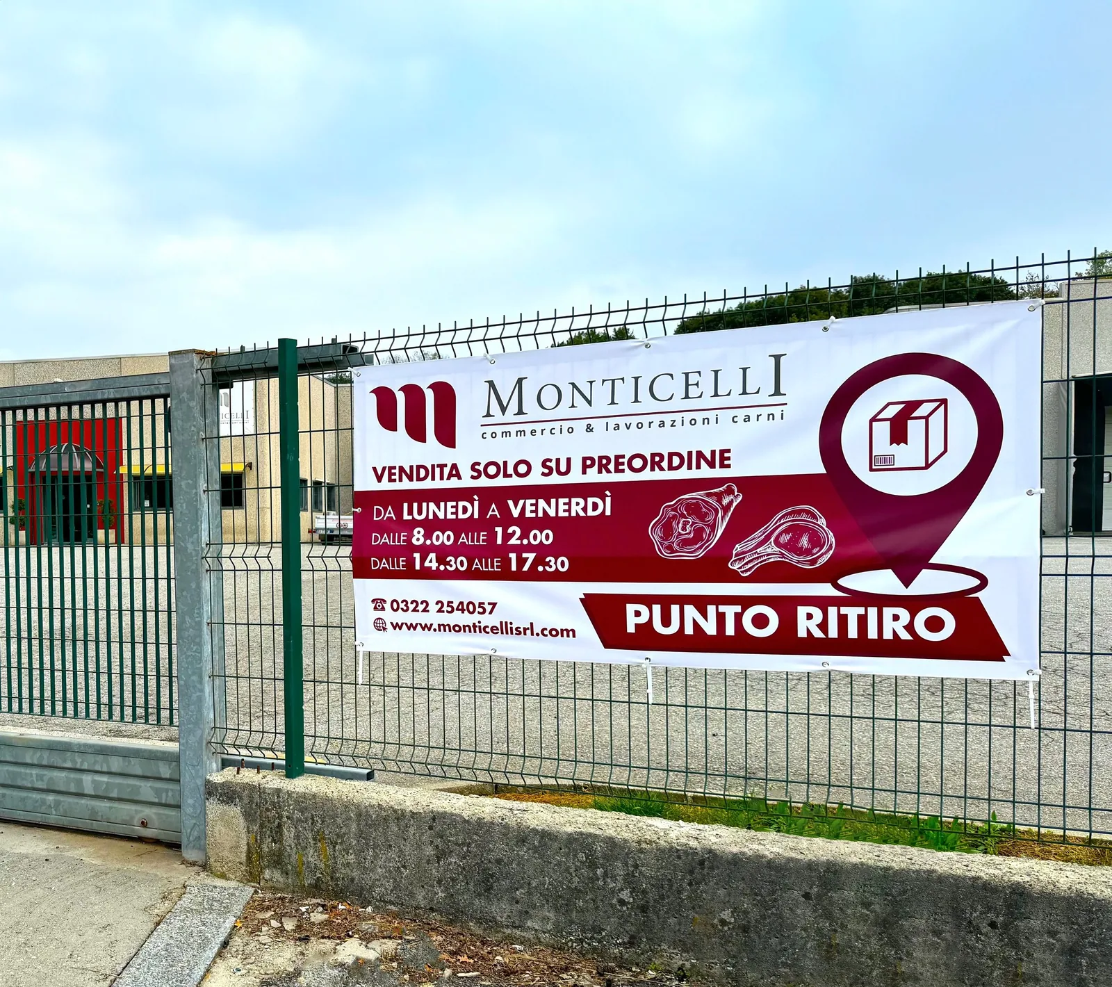 Banner Monticelli «Punto ritiro» con orari, teso sulla recinzione dello stabilimento