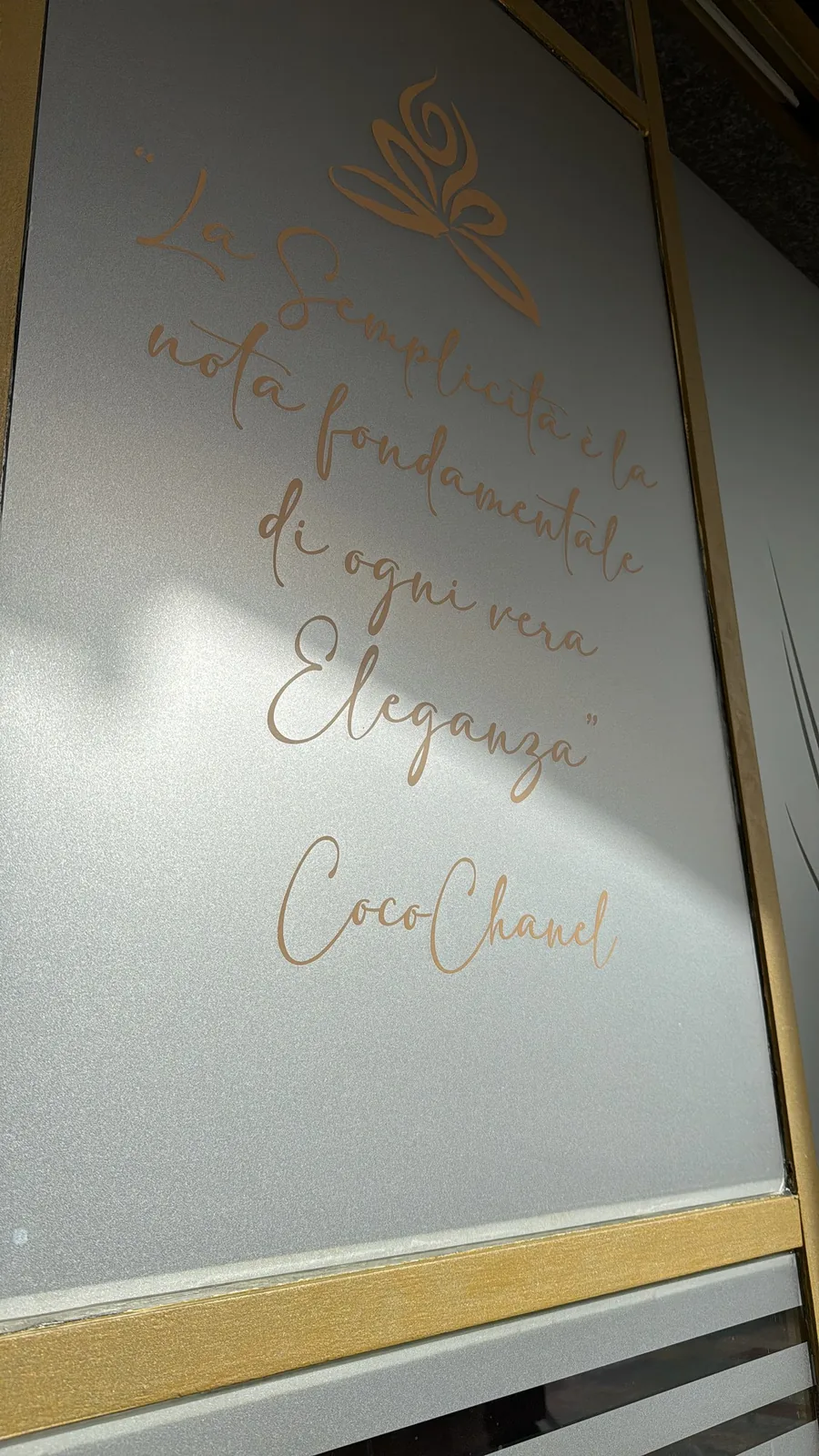 Vetrofania satinata con la citazione di Coco Chanel in lettere oro