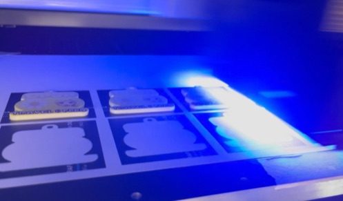 Stampante UV al lavoro su gadget in piano